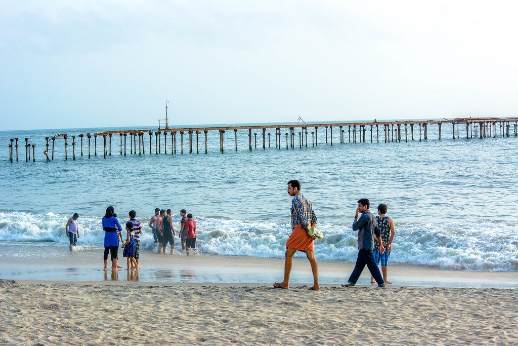 Family walk along Alleppey shoreline in evening
