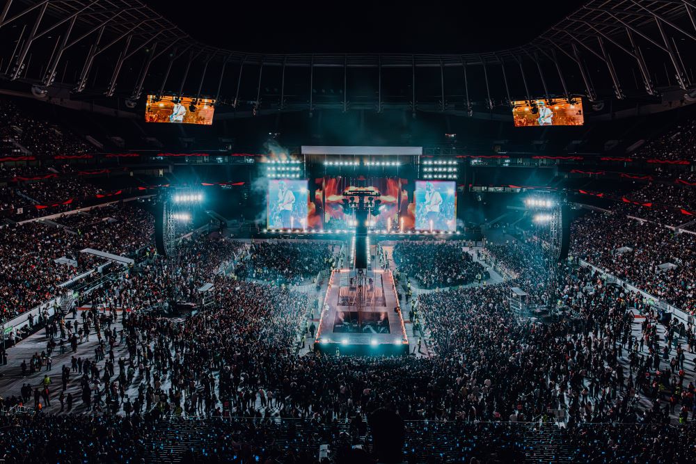 Massive crowd enjoying Arijit Singh concert with glowing lights and energy