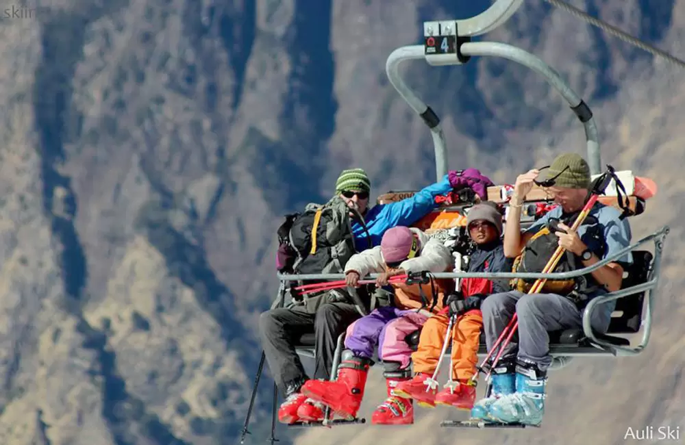 Travelers enjoying scenic ropeway and meadow viewpoints in Auli
