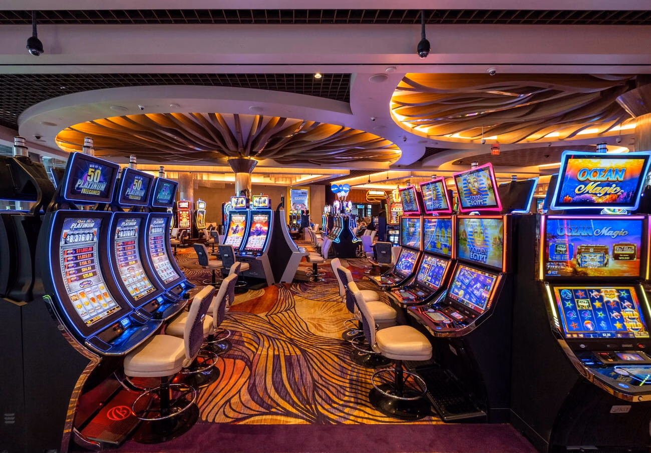 Casino gaming floor with roulette tables, card games, and slot machines
