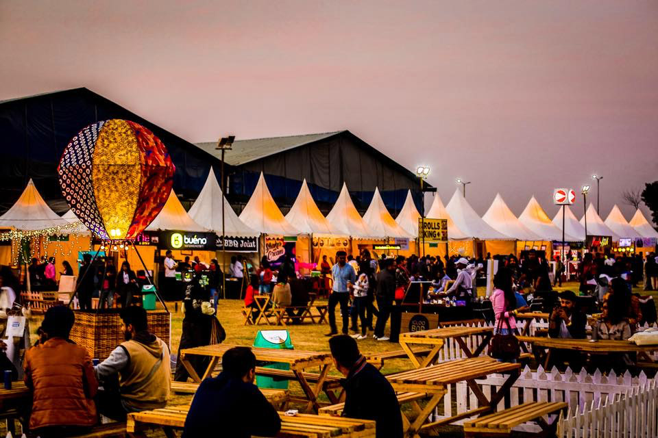 Crowded Indian food festival with regional stalls and live cooking