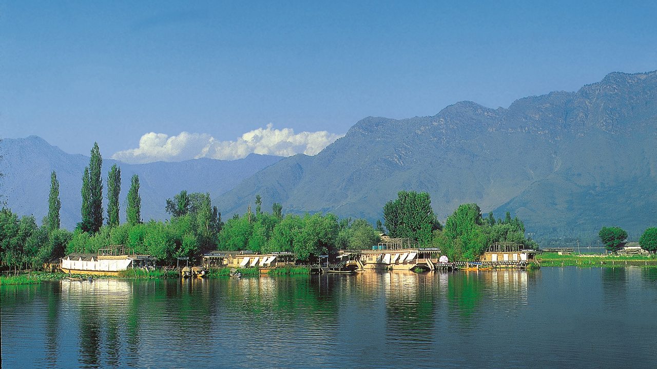 Dal Lake view in Srinagar with mountains and traditional shikara