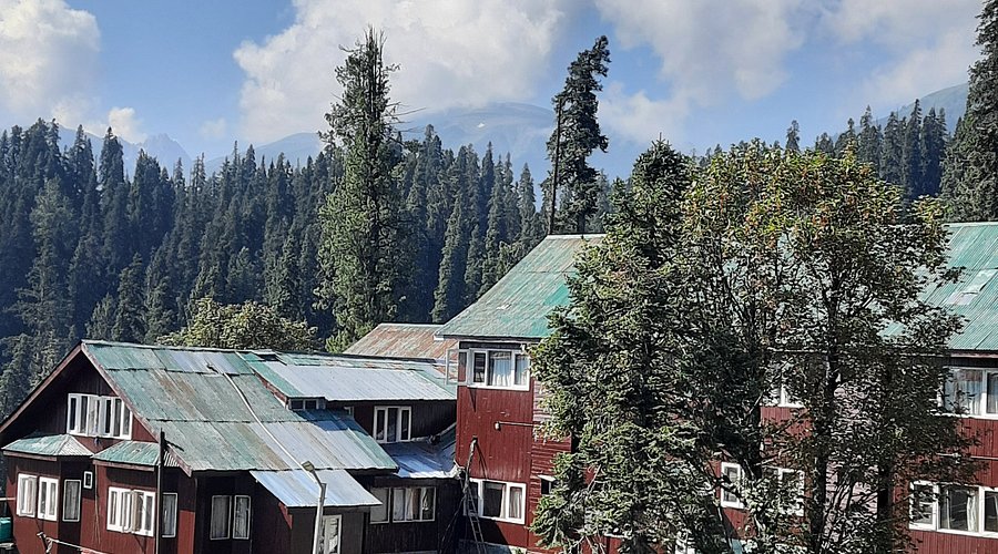 Gulmarg valley meadow with cable car line and distant snow peaks