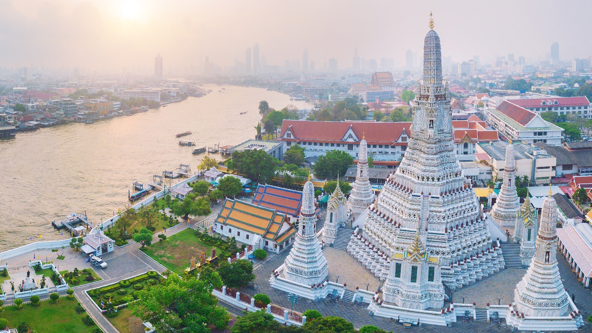 Wat Arun Temple prangs silhouetted against Bangkok sky at sunset